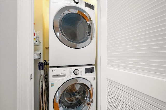 clothes washing area featuring laundry area and stacked washing maching and dryer