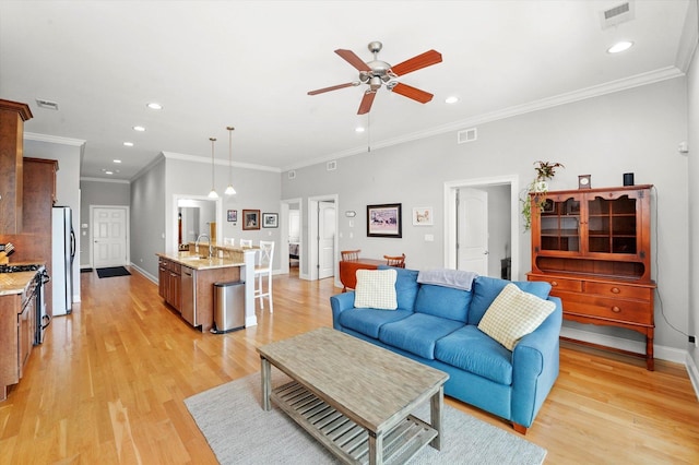 living area with a ceiling fan, recessed lighting, visible vents, and light wood finished floors