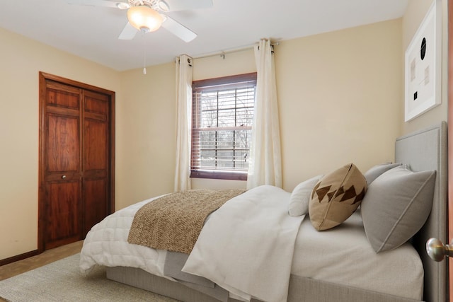 bedroom featuring a closet, baseboards, carpet flooring, and a ceiling fan