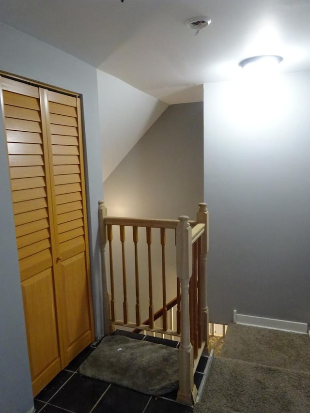 staircase with lofted ceiling and tile patterned flooring