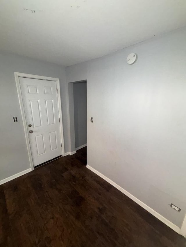 spare room with dark wood-style floors and baseboards