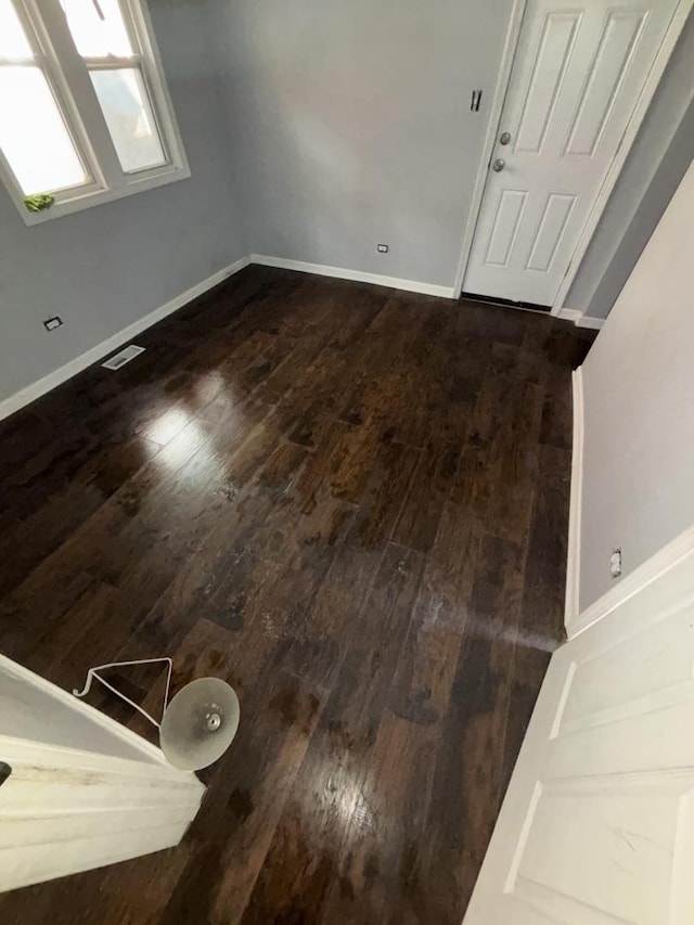 interior space featuring visible vents, dark wood finished floors, and baseboards