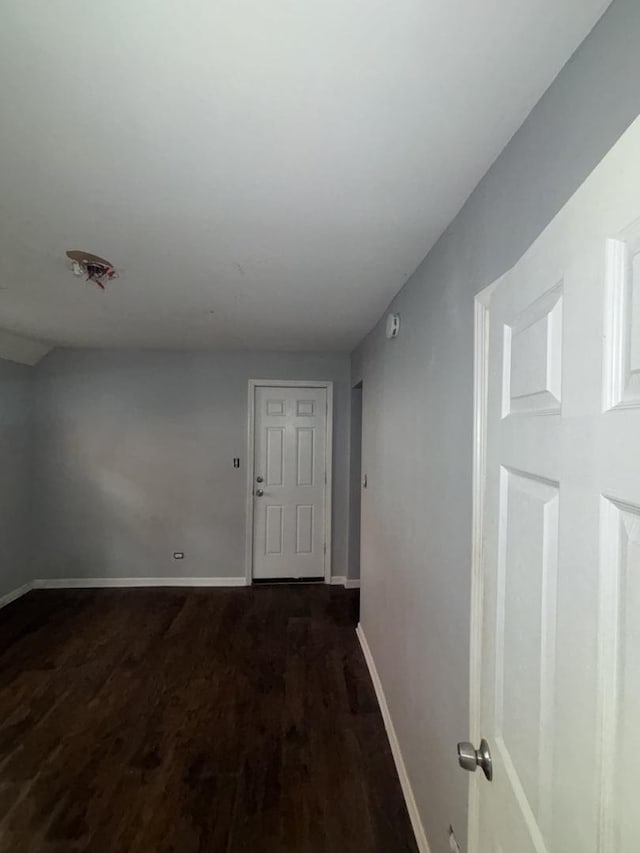 hallway featuring baseboards and wood finished floors