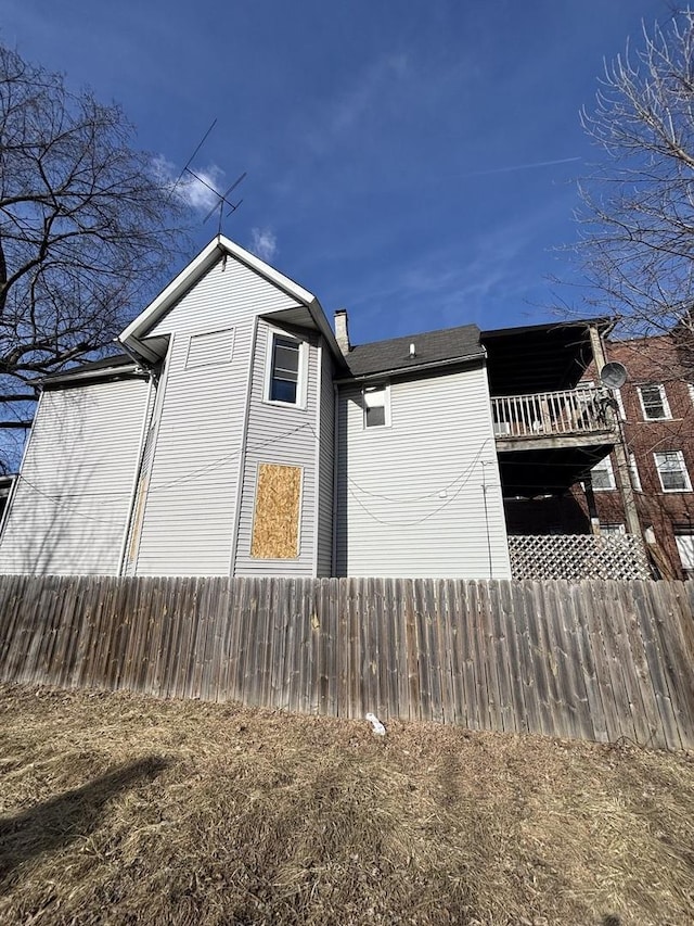 view of home's exterior featuring fence and a chimney