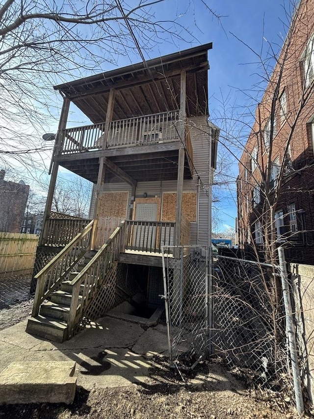 rear view of property featuring fence and a balcony