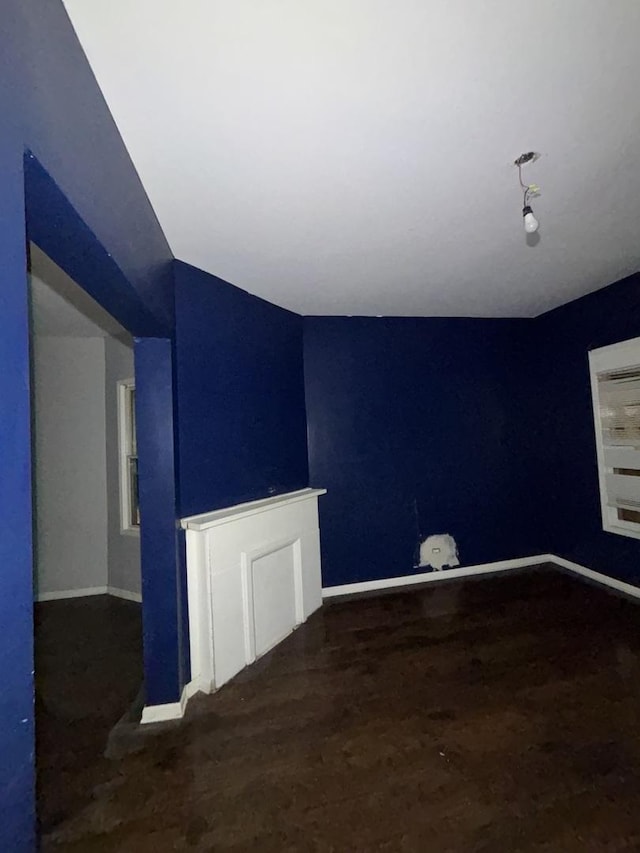 spare room with baseboards and vaulted ceiling