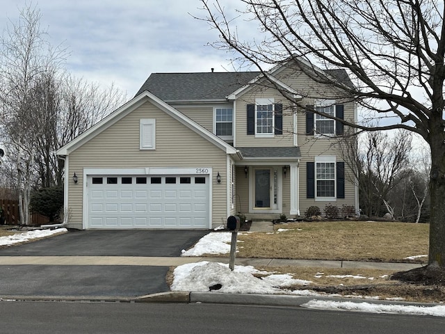 traditional-style house featuring aphalt driveway, a shingled roof, and an attached garage