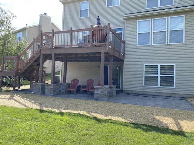 back of house featuring a patio area, a deck, and a lawn