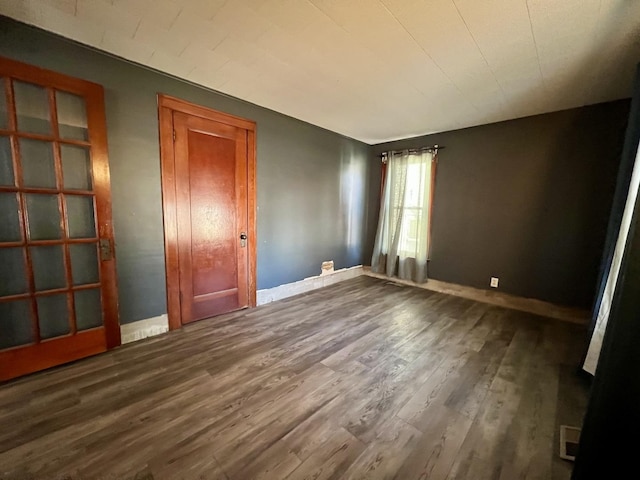 unfurnished bedroom with visible vents, baseboards, and wood finished floors