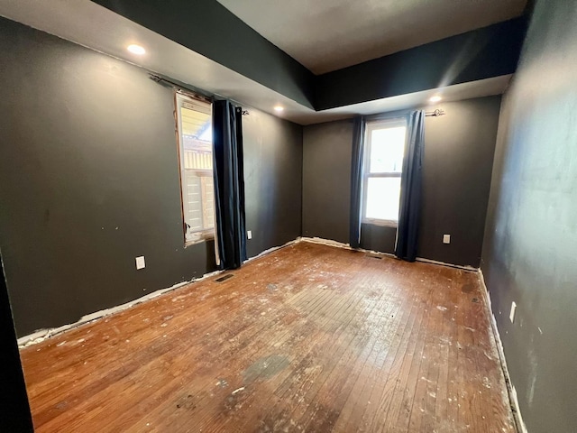 empty room featuring wood-type flooring and visible vents