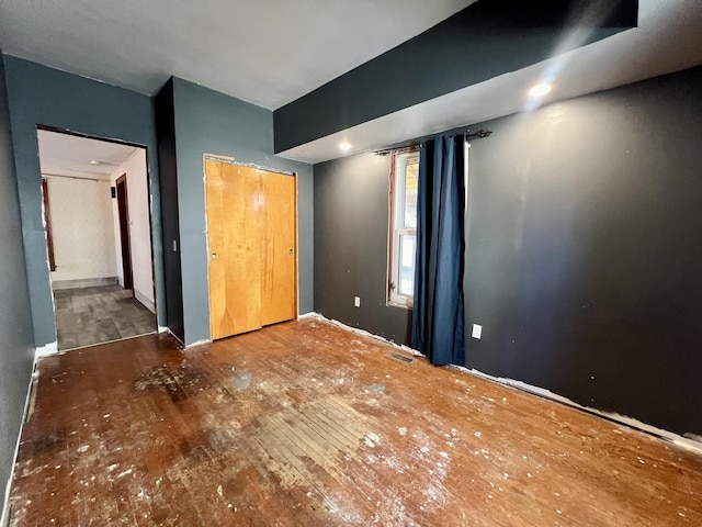 unfurnished bedroom with a closet, visible vents, and wood finished floors