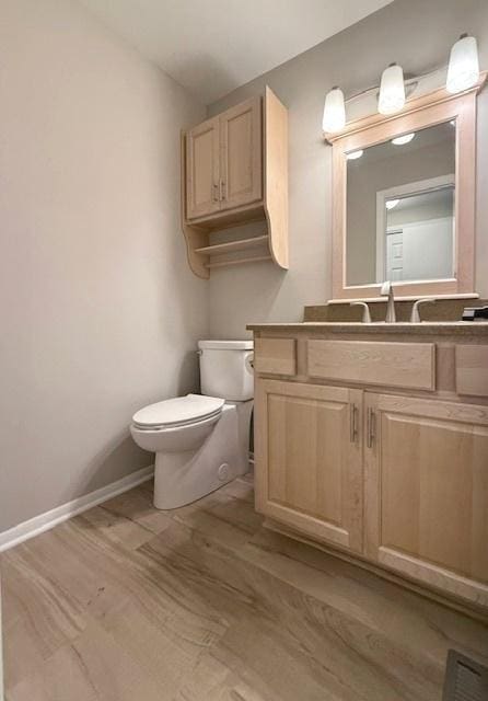 1816 Sadler Dr, Champaign, IL 61821 - half bathroom featuring toilet, wood finished floors, vanity, and baseboards