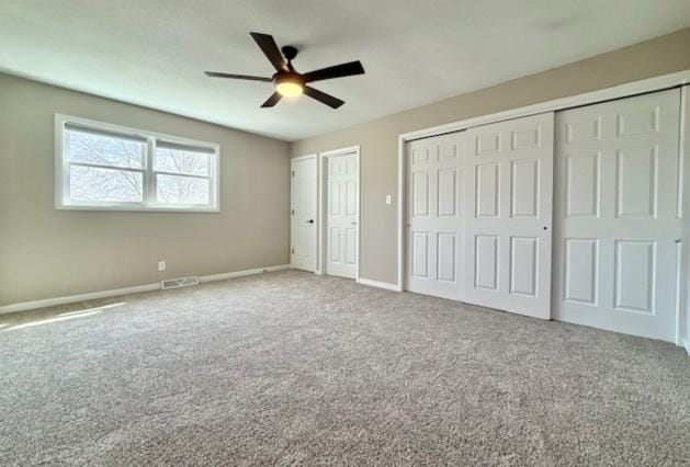 1816 Sadler Dr, Champaign, IL 61821 - unfurnished bedroom with carpet, baseboards, a ceiling fan, and multiple closets