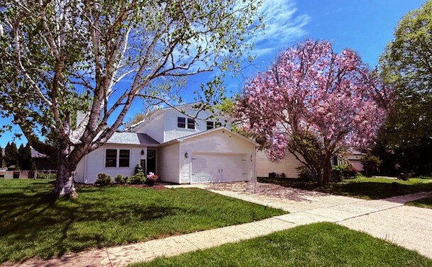 1816 Sadler Dr, Champaign, IL 61821 - view of front of home featuring a front yard, an attached garage, concrete driveway, and stucco siding