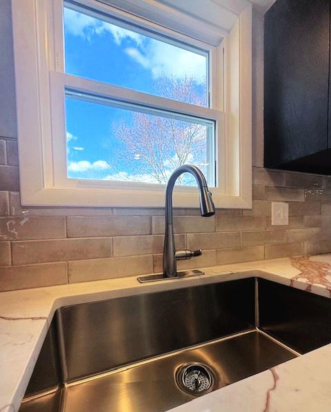 1816 Sadler Dr, Champaign, IL 61821 - kitchen view of a sink, decorative backsplash, and light stone countertops