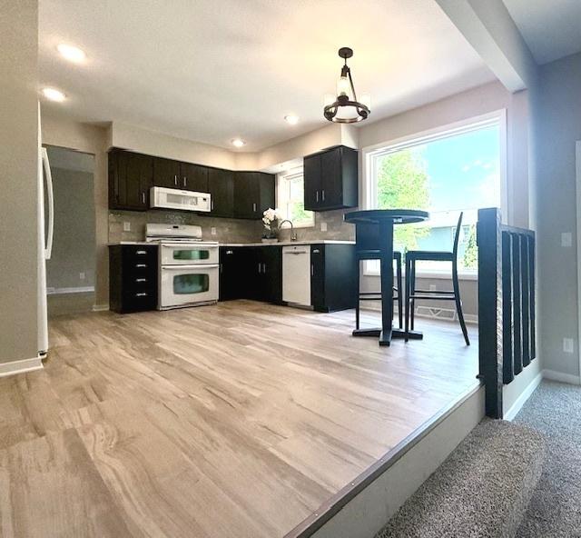 1816 Sadler Dr, Champaign, IL 61821 - kitchen with double oven range, dishwasher, white microwave, baseboards, and light countertops