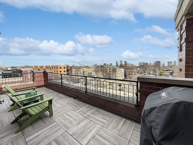 wooden terrace with grilling area and a city view