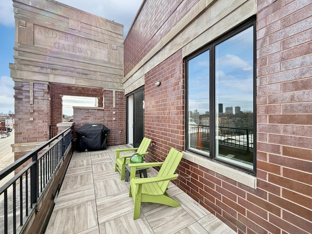 wooden deck with a view of city and a grill