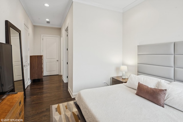 bedroom with baseboards, crown molding, wood finished floors, and recessed lighting