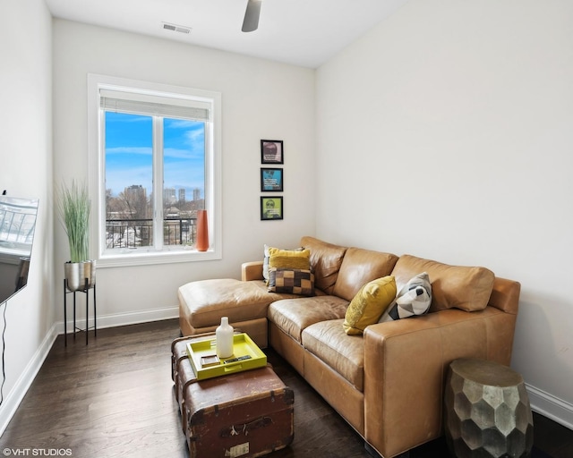 living area with dark wood-style floors, ceiling fan, visible vents, and baseboards