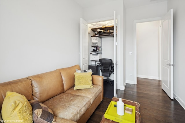 living area with dark wood-type flooring and baseboards