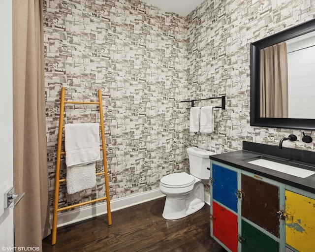 bathroom featuring baseboards, vanity, toilet, and wood finished floors