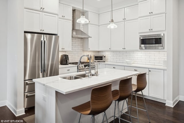 kitchen featuring dark wood-type flooring, a sink, white cabinets, appliances with stainless steel finishes, and decorative backsplash