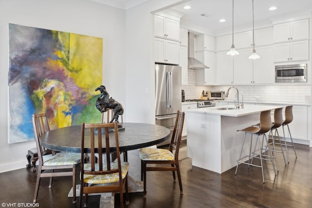 kitchen featuring light countertops, appliances with stainless steel finishes, dark wood-type flooring, and tasteful backsplash