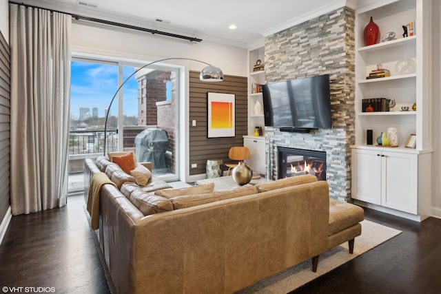 living area featuring built in shelves, recessed lighting, dark wood-style flooring, a fireplace, and ornamental molding