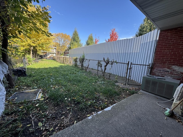 view of yard with a fenced backyard and central AC