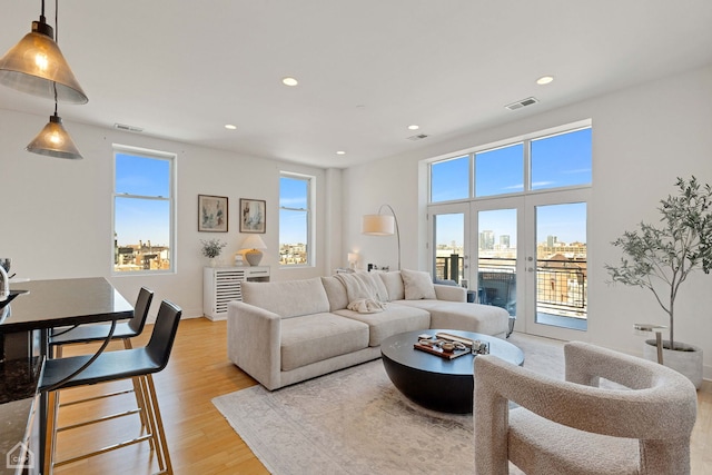 living room featuring light wood-style flooring, visible vents, and recessed lighting