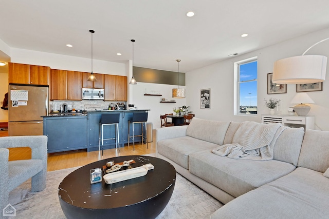 living area featuring light wood-style flooring and recessed lighting