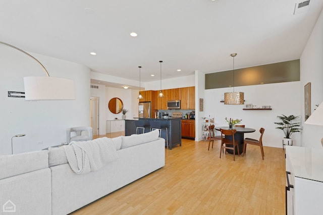 living area featuring light wood-style floors, visible vents, and recessed lighting