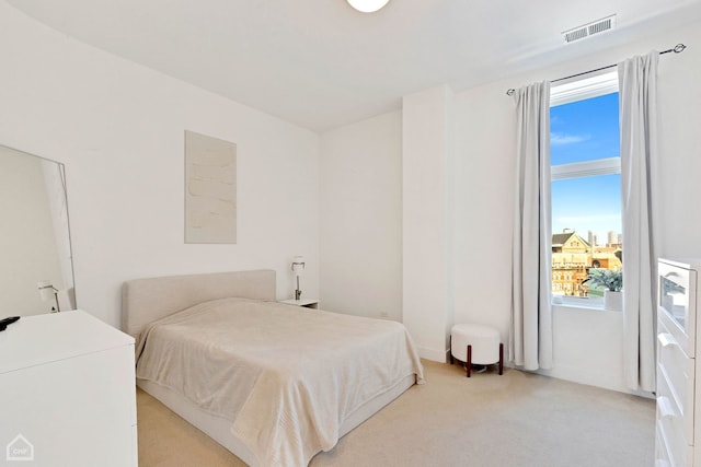 bedroom featuring light carpet and visible vents