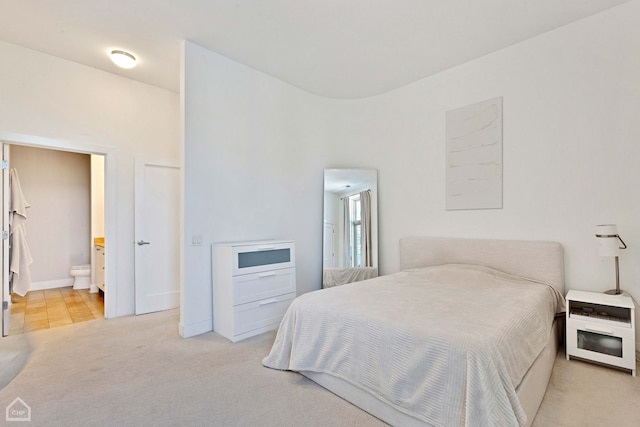 bedroom featuring light carpet and ensuite bathroom