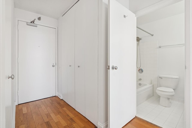 full bathroom with a closet, tub / shower combination, toilet, and wood finished floors