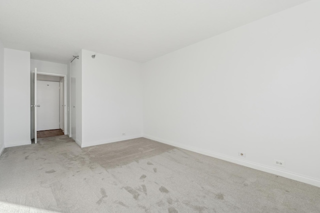 unfurnished bedroom featuring light carpet and baseboards