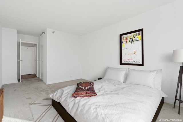 bedroom featuring light colored carpet and baseboards