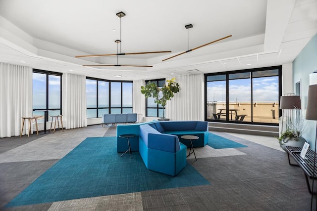 living area featuring expansive windows, a tray ceiling, and recessed lighting