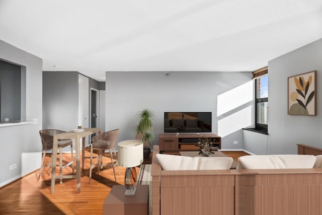 living area with light wood-style flooring and baseboards