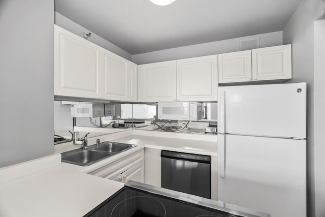 kitchen with light countertops, white appliances, a sink, and white cabinets