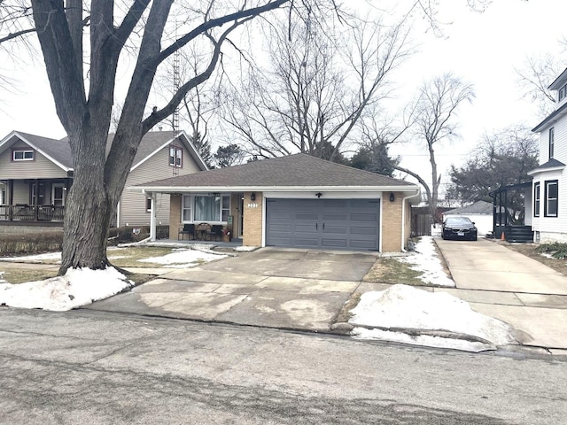 view of front facade featuring an attached garage, a shingled roof, concrete driveway, and brick siding