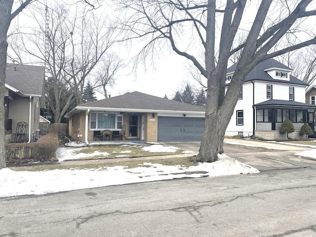 view of front of property featuring a garage, driveway, and brick siding