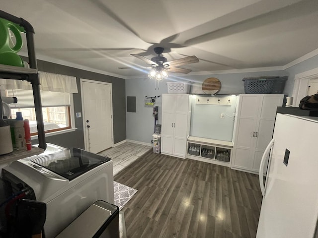 kitchen with white cabinets, freestanding refrigerator, dark wood-style floors, washer / dryer, and crown molding