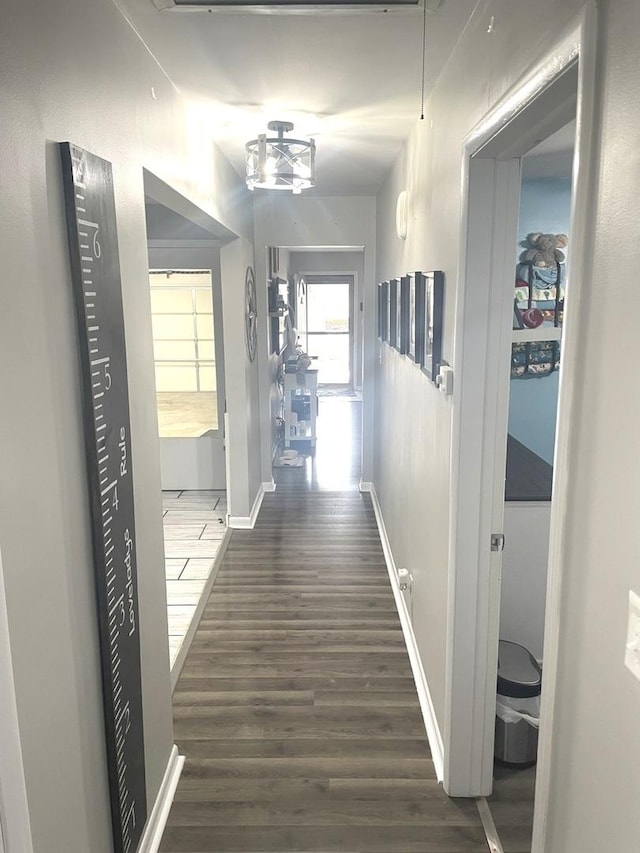 hall with baseboards and dark wood-style flooring