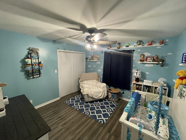 interior space featuring ceiling fan, dark wood-type flooring, a closet, and baseboards