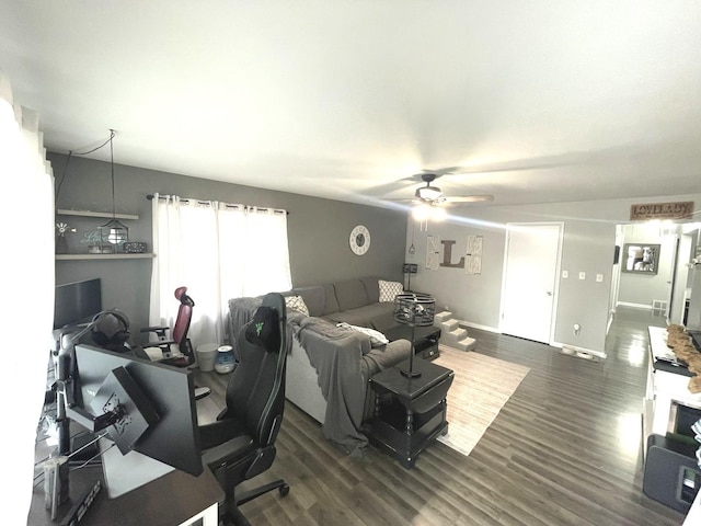 living area with baseboards, dark wood finished floors, and a ceiling fan