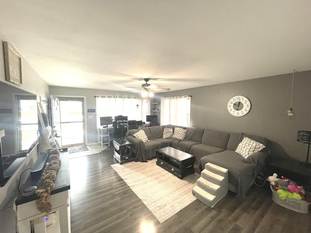 living room featuring dark wood-type flooring and a ceiling fan