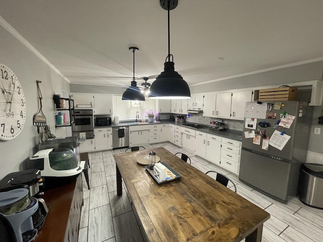 kitchen featuring dark countertops, black appliances, white cabinetry, and a sink