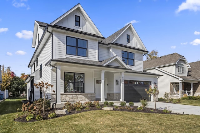 modern farmhouse style home featuring a porch, an attached garage, stone siding, driveway, and a front lawn